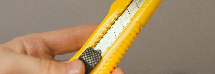 Hand hält Teppichmesser